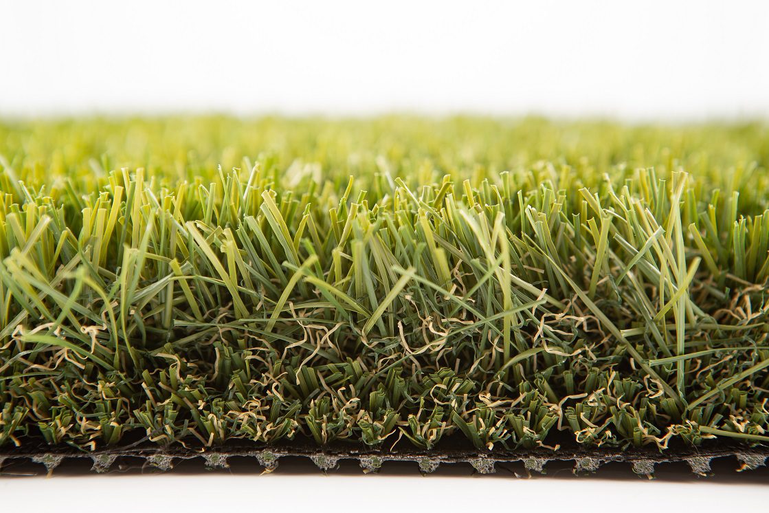 Close-up of lush artificial turf blades and black backing.